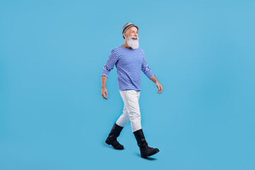 Full body photo of positive happy old man look go empty space sailor outfit isolated on blue color...