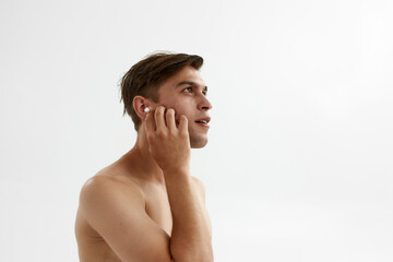 Fototapeta na wymiar Young thoughtful man listening music in earphones