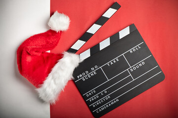 Christmas hat with film board cutout on red and white background. Christmas film. - 471255736