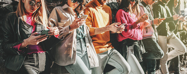 A group of young digital native people using smartphone together - friends phubbing and addiction to cellphones concept