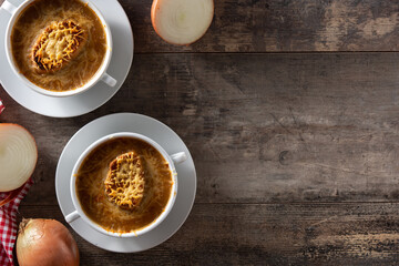 Traditional french onion soup on wooden table. Top view. Copy space