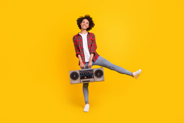Fototapeta premium Full length body size view of attractive carefree cheerful girl dancing holding player isolated over bright yellow color background