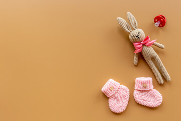 Fototapeta na wymiar Kids toy knitted rabbit with baby booties shoes, top view