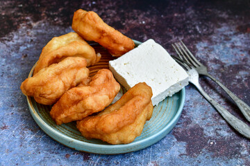Traditional Bulgarian home made deep fried  patties  covered with sugar  оn rustic backgroud.Mekitsa or Mekica,  on wooden  rustic  background. Made of kneaded dough that is deep fried 