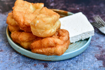 Traditional Bulgarian home made deep fried  patties  covered with sugar  оn rustic backgroud.Mekitsa or Mekica,  on wooden  rustic  background. Made of kneaded dough that is deep fried 