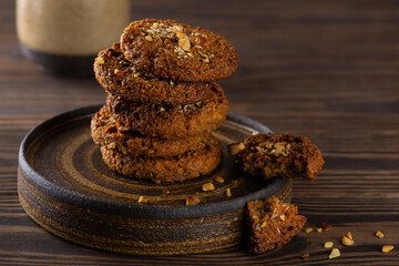 Quinoa cookies and stacked nuts on a dark plate. Sugar, gluten and lactose free and vegan.