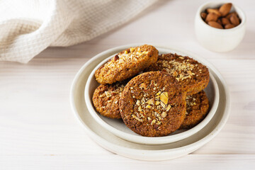 Homemade oatmeal cookies with carrots, nuts and quinoa on a light plate. Sugar, gluten and lactose free and vegan.