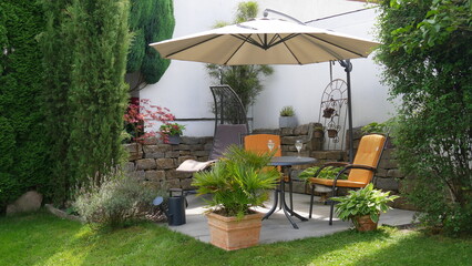 Ein Glas Wein auf der Gartenterrasse mit Sitzgruppe, Hängeschaukel und Sonnenschirm