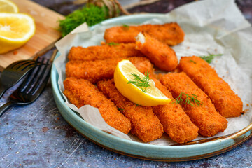  Fish and chips.Close up of crispy breaded  deep fried alaska pollock  fillets  with breadcrumbs served with remoulade sauce french fries  and  lemons