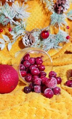 Fototapeta na wymiar red frozen cherries, red Christmas decorations and a wreath of branches of the Christmas tree