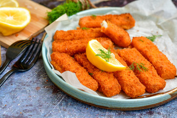  Fish and chips.Close up of crispy breaded  deep fried alaska pollock  fillets  with breadcrumbs served with remoulade sauce french fries  and  lemons