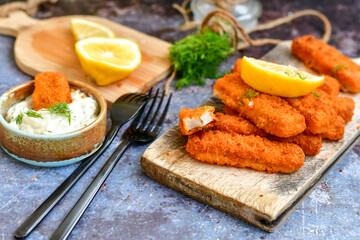  Fish and chips.Close up of crispy breaded  deep fried alaska pollock  fillets  with breadcrumbs served with remoulade sauce french fries  and  lemons