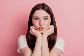 Closeup photo of pretty girl sending air kisses drean hands touch chin isolated bright pink color background