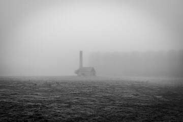 Fototapeta premium Old building through thick fog in black and white