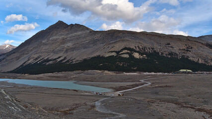 View of Athabasca River Valley in Jasper National Park,  Canada with lake, rocky glacial moraine, car park and visitor center at Icefields Parkway.