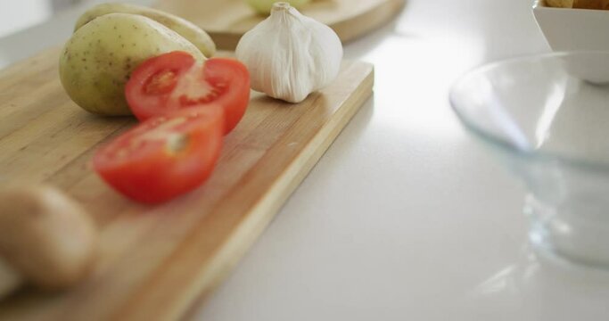 Vegetables and garlic on wooden chopping board in kitchen