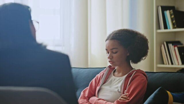 Teen counselor talking to sad black girl, discussing problem, bullying victim