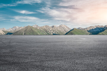 Empty asphalt road and mountain under blue sky