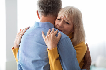 Senior Wife Hugging Husband Comforting And Supporting Him At Home