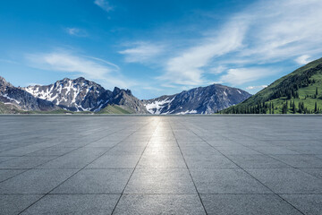 Empty square floor and mountains under blue sky. Road and mountain background.