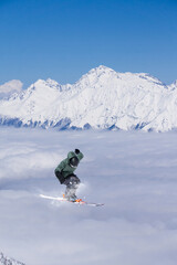 Naklejka na ściany i meble A jumping skier in the mountains. Mountain ski, winter extreme sport.