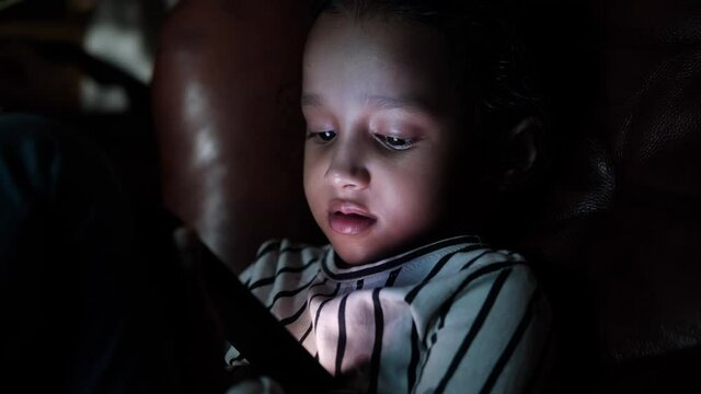 child girl laying on floor using smart phone at night 