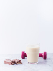Banana coconut smoothie and protein bar on bright stone background. Soft focus. Copy space.	