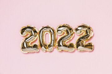 New year 2022 balloon celebration card. Gold foil helium balloon number 2022 isolated on pink background. Flat lay, merry christmas, happy holidays mockup.