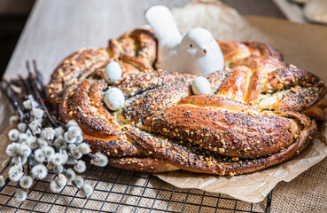 Easter twist bread with poppy seed and nut filling decorated with willow twigs and Easter eggs. Homemade babka or brioche bread.