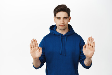 Stop this. Serious concerned man showing block, taboo gesture, say no, prohibit smth, raising palms...
