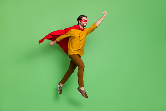Full length profile photo of funky young superhero guy run wear mask courage shirt trousers shoes isolated on green background
