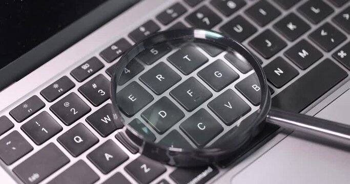Magnifying glass lies on computer keyboard slow motion 4k movie