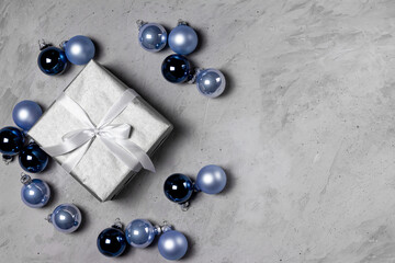Christmas and New Year. theme postcard, frame, banner. Silver Christmas gifts with dark balls, decorations on a gray background top view. Flat lay.