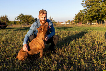 Human and canine spending time on the open field gaining mutual trust and companionship