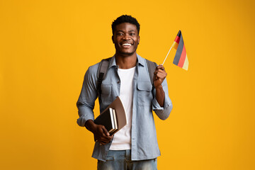 Happy black guy student showing flag of Germany
