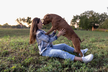 Trust and loyalty between a young woman and her female pet dog, girls bonding in the countryside