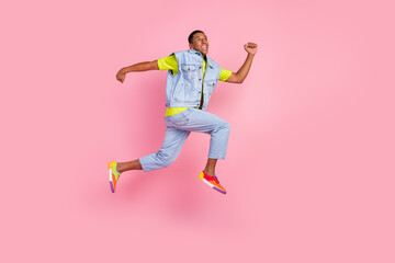 Fototapeta na wymiar Full body profile photo of impressed millennial brunet guy jump wear t-shirt vest jeans old school isolated pink background