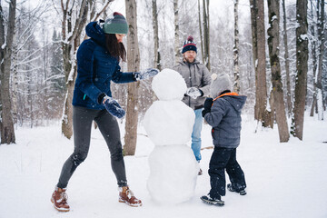 Children play outdoors in snow. Outdoor fun for family Christmas vacation. Two little kid boy and...
