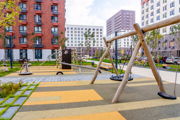 Moscow, Russia - 04.10.2021: Beautiful multi colorful building of new modern residential area for young families. Playground in public yard. Residential district with bright facade geometry
