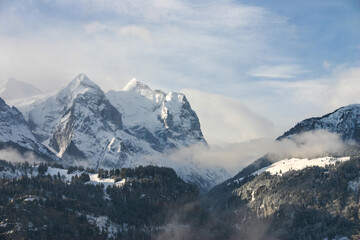 Naklejka na ściany i meble intense mood mountain range in switzerland alps, strong clouds and bright light at midday