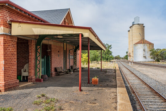 A regional railway line running past an abandoned station and regional wheat silos