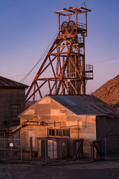 Abandoned sheds and poppet head at a mining plant at twilight