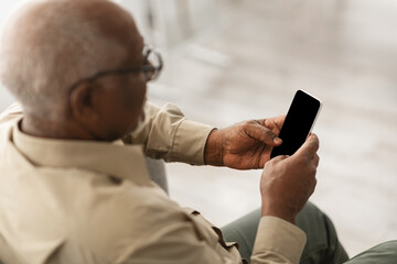 Senior African American Man Using Phone With Empty Screen Indoors - Powered by Adobe