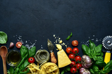 Culinary background with traditional  ingredients of italian cuisine : pasta, tomatoes, garlic, olive oil, parmesan cheese, basil. Top view with copy space.