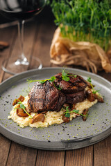 Gourmet veal medallions with risotto on wooden background