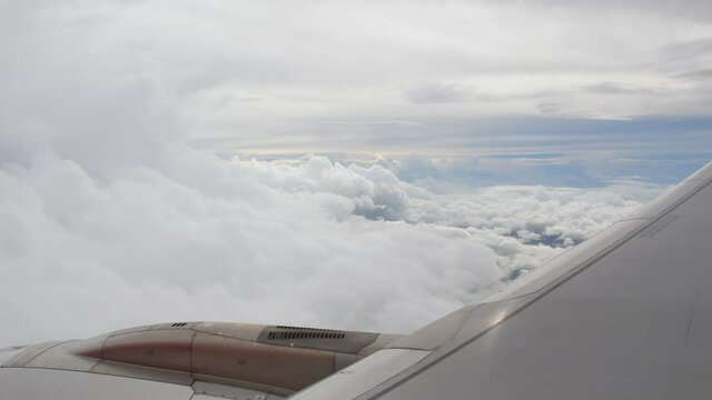 View of the plane wing through the airplane window. Air Transportation flying over the cloud