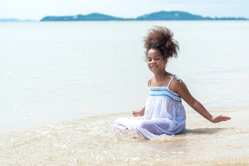 Fototapeta na wymiar happy african american Little girl sitting and play on the beach