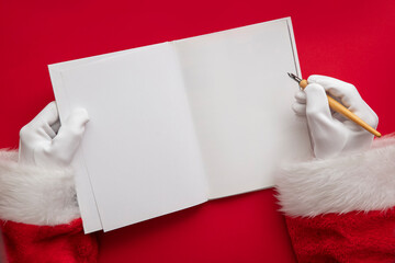 Santa Claus writing a naughty or nice list in a book. blank page mock up