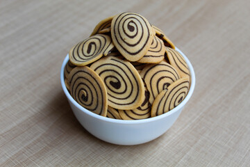Kue Kuping Gajah, traditional cookies from Indonesia. Sweet and crunchy, unique spiral pattern. Wooden background.