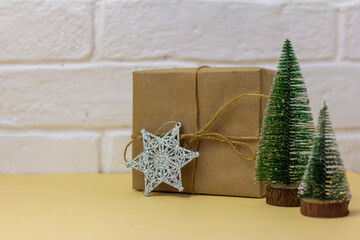 Craft paper gift boxes and small Christmas trees, copy space. Christmas concept.